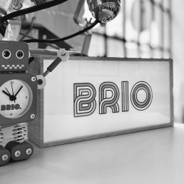 Photo of robot and brio media sign in office